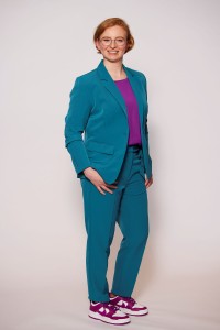 Ganzkörperfoto junge Businessfrau im türkisen Hosenanzug nach Umstyling